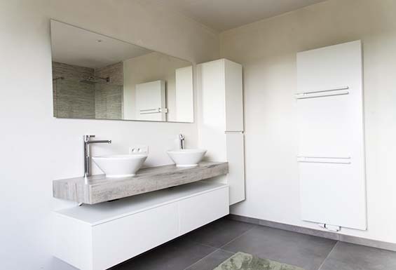 Badkamer met zwevend meubel en designradiator